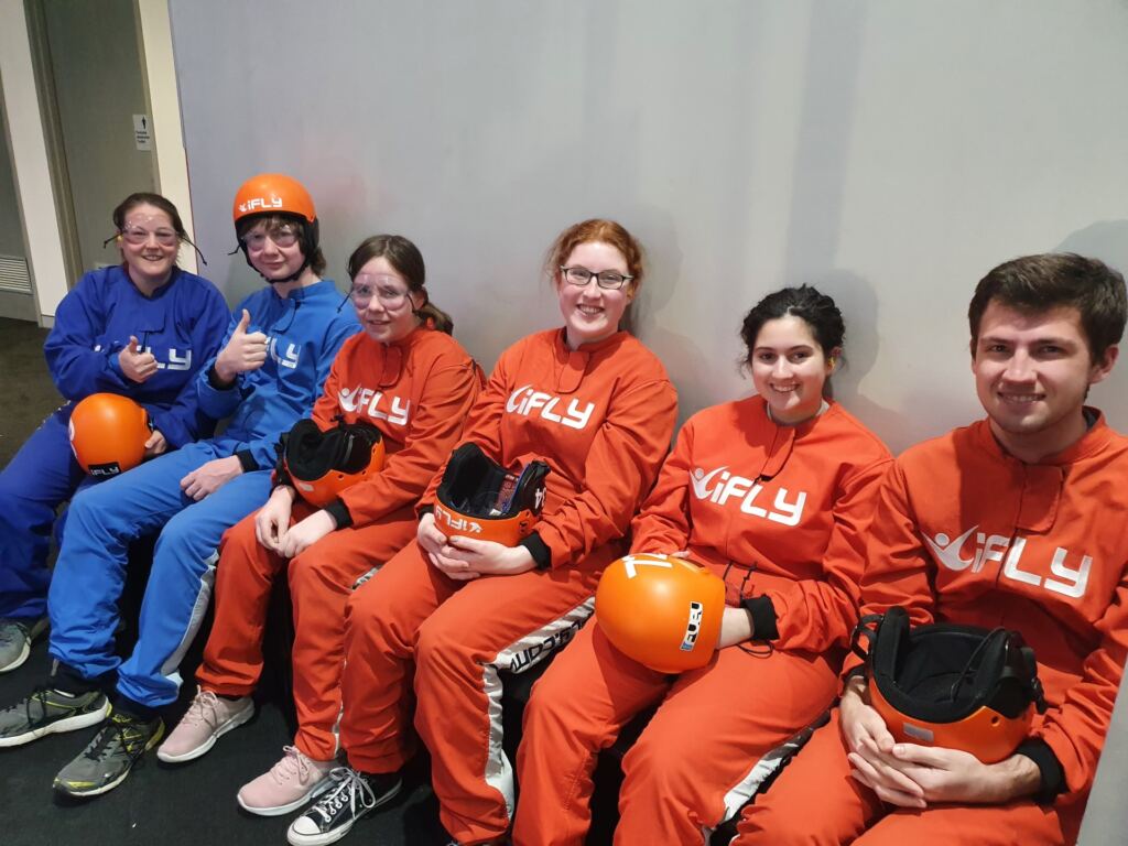 The Narrow Escape Room staff team dressed in fly suits at iFLY Downunder.